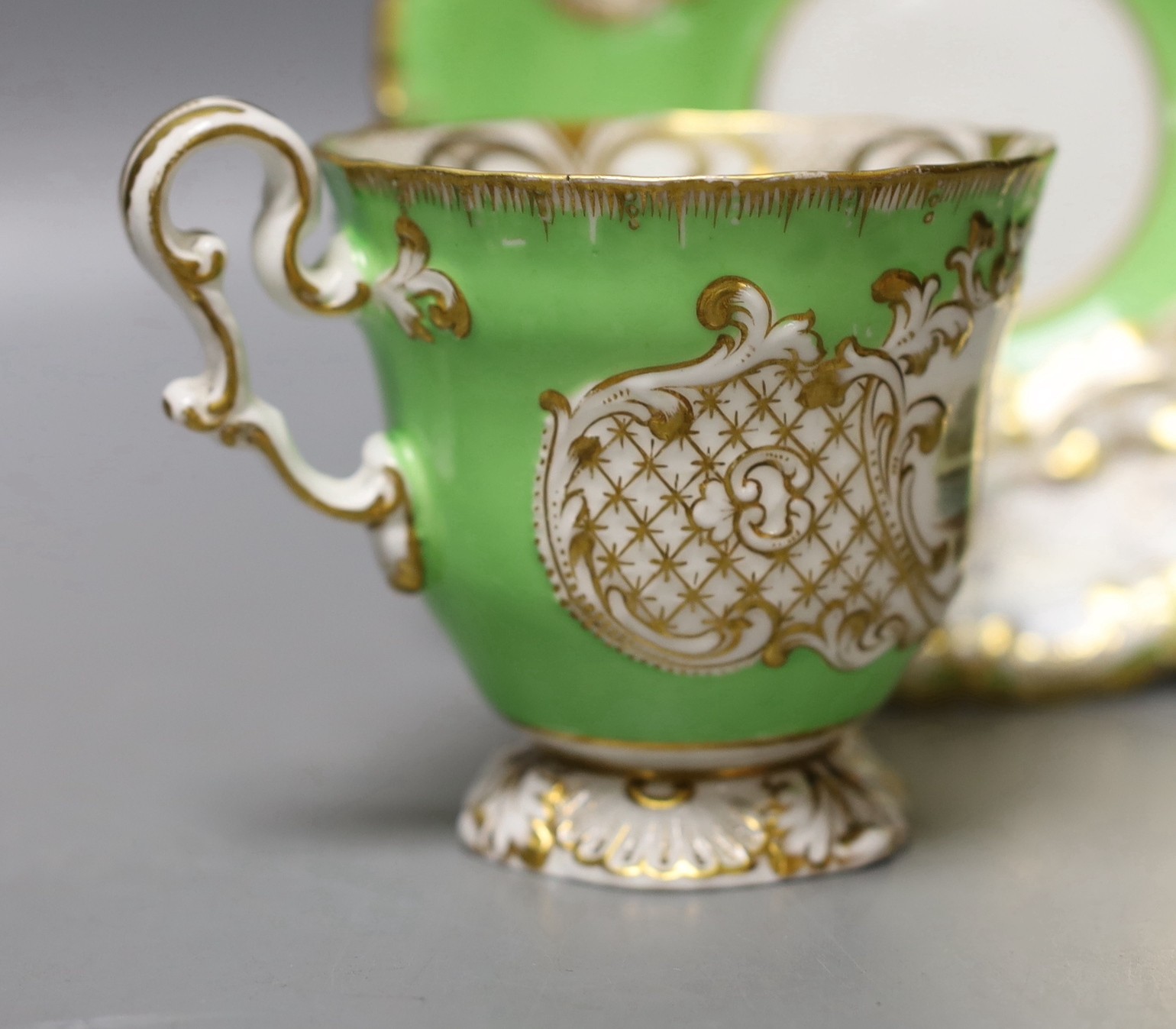 Copeland and Garrett fine topographical pedestal coffee cup and saucer with green ground painted with Sion House on the cup and Lincoln and Malsbury Abbey on the saucer c. 1840